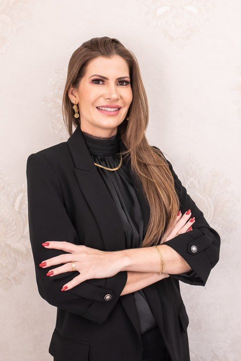 Dra. Michelle Dora Budin de blazer preto, com os braços cruzados, sorrindo